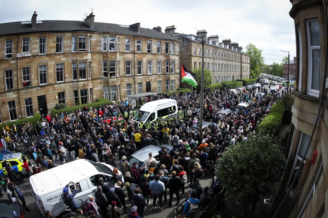Protestors block an UK home office immigration enforcement van after an attempted raid was carried out in the morning in Kenmure Street in Pollokshields, Glasgow, Scotland.