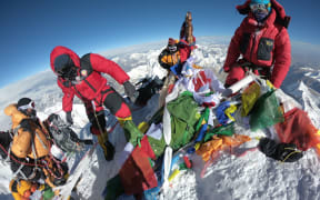 In this photo taken on May 17, 2018, mountaineers and sherpas gather at the summit of Mount Everest after ascending on the south face from Nepal. (Photo by PHUNJO LAMA / AFP)