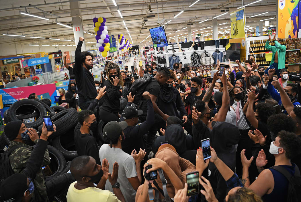 Demonstrators make a barrier out of car tyres inside the supermarket Carrefour in Rio de Janeiro, Brazil.