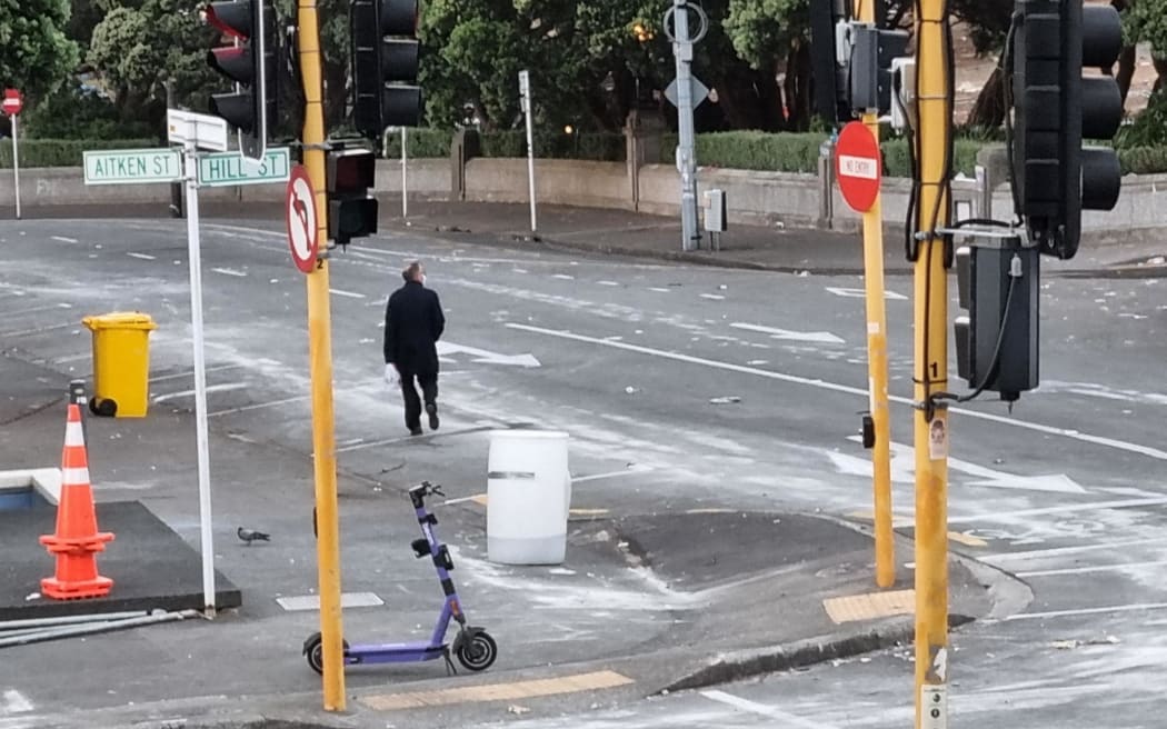 A pedestrian walks past Parliament grounds on the morning of 3 March, 2022, a day after the police operation to end the protest occupation.