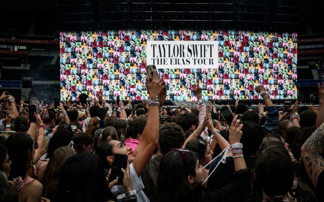 Fans wait for the arrival on stage of US singer and songwriter Taylor Swift (up) at the Groupama Stadium as part of The Eras Tour, in Decines-Charpieu, eastern France, on June 2, 2024.