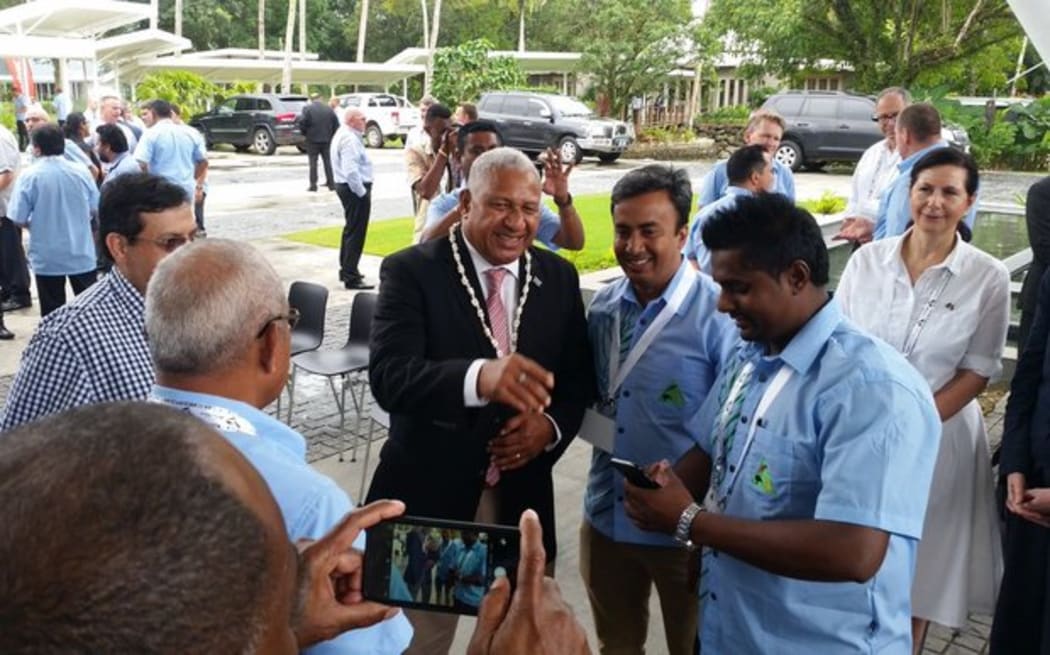 The Fiji Prime Minister Frank Bainimarama meets local & international business people in Fiji at the Fiji/Australia Business council Forum while Australian dignitaries look on.