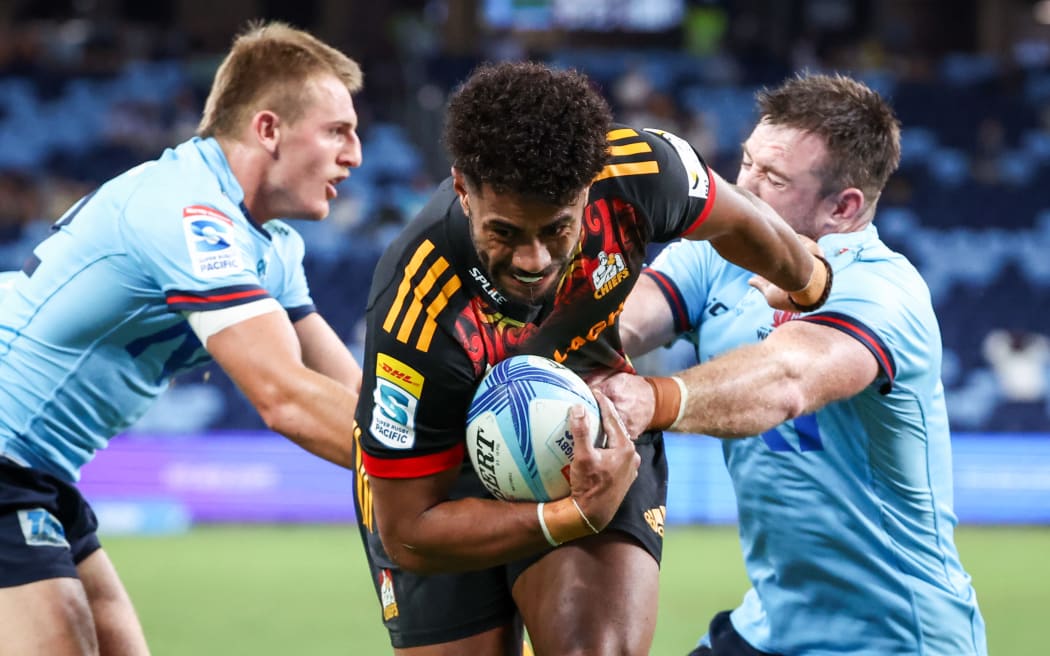 Emoni Narawa (C) from the Chiefs avoids a tackle from Jed Holloway (R) from the Waratahs.