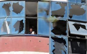 A Palestinian girl looks out through the shattered glass of one of her home's windows in Gaza City, Palestine, on April 26, 2025, amid the ongoing conflict between Israel and the militant group Hamas. (Photo by Majdi Fathi/NurPhoto) (Photo by MAJDI FATHI / NurPhoto / NurPhoto via AFP)