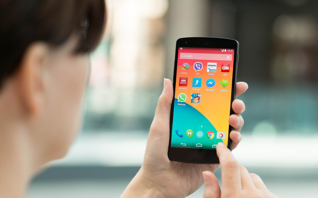 Kiev, Ukraine - September 14, 2014: Woman using a brand new Google Nexus 5 outdoors.