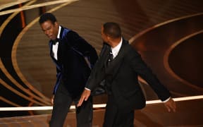 In this file photo taken on March 27, 2022, US actor Will Smith (R) slaps US actor Chris Rock onstage during the 94th Oscars at the Dolby Theatre in Hollywood, California. - Will Smith has posted an emotional new apology for slapping Chris Rock at the Oscars earlier this year, revealing in a lengthy video clip, posted to social media on July 29, 2022, that he has reached out to the comedian who was not yet "ready to talk."
