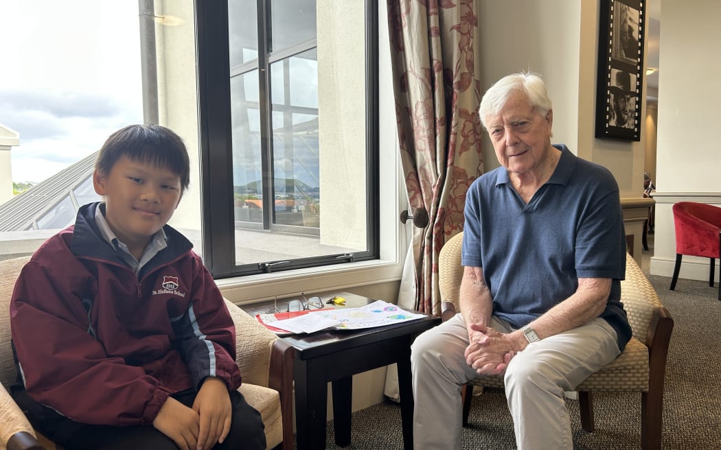 Photo of a boy and an elderly man, smiling at the camera.