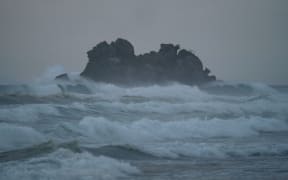 Waves crashing against rock formation island pacific ocean coast sea shore at Opoutere beach Waikato Coromandel Peninsula North Island New Zealand