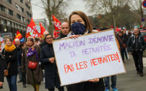 Demonstrators hold sign and flag fron Trade Unions during a demonstration in Lille.