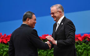 China's Premier Li Qiang (L) and Australia's Prime Minister Anthony Albanese shake hands during the opening ceremony of the 6th China International Import Expo (CIIE) in Shanghai on November 5, 2023. (Photo by Hector RETAMAL / AFP)