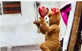 An undercover cop dressed as a teddy bear kneels outside the home of an alleged drug dealer in the Peruvian capital, Lima.
