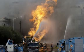 Pacific Gas and Electric workers work as San Francisco firerighters battle a fire in San Francisco, Wednesday, Feb. 6, 2019.