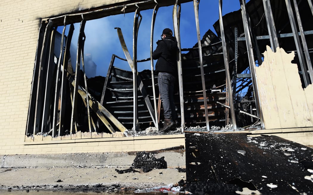 A journalist photographs a burnt-out store in Ferguson, Missouri, which was set ablaze following the grand jury decision.