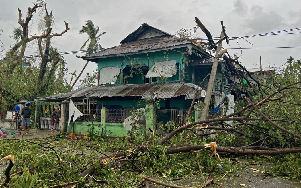 Local residents check the damages after Cyclone Mocha crashed ashore, in Kyauktaw in Myanmar’s Rakhine state on May 14, 2023. Cyclone Mocha crashed ashore in Myanmar and southeastern Bangladesh on May 14, uprooting trees, scattering flimsy homes in Rohingya displacement camps and bringing a storm surge into low-lying areas. (Photo by SAI Aung MAIN / AFP)