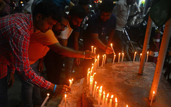 People light candles as they take part in a prayer ceremony in Siliguri on June 12, 2025, for the victims of the airplane crash in India's Ahmedabad city. Thick black plumes of acrid smoke towered high above India's Ahmedabad airport on June 12 after a London-bound passenger jet with 242 people aboard crashed shortly after takeoff. (Photo by Diptendu DUTTA / AFP)