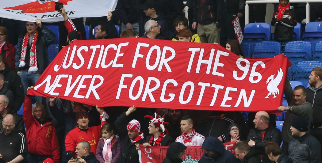 Liverpool fans hold up banners commemorating those who lost their lives in the 1989 Hillsborough disaster.