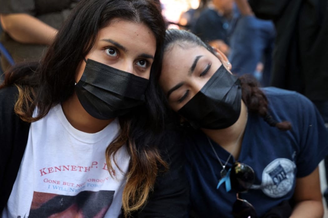 NEW YORK, NEW YORK - SEPTEMBER 11: Two women embrace during a ceremony at the National September 11 Memorial & Museum commemorating the 20th anniversary of the September 11th terrorist attacks on the World Trade Center on September 11, 2021 in New York City.