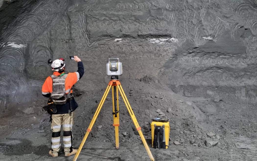 A surveyor working at the tunnel face