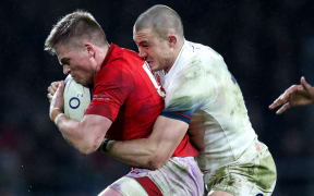 Welsh fullback Gareth Anscombe is wrapped up in a tackle by England counterpart Mike Brown.