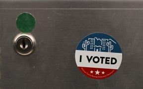 An "I Voted" sticker is displayed on a demonstration ballot lock box at the Maricopa County Tabulation and Election Center (MCTEC) ahead of the 2024 Arizona Primary and General elections in Phoenix, Arizona on June 3, 2024. Maricopa County election workers have repeatedly been the target of harassment and threats since the 2020 US election due to the spread of online misinformation about voter fraud. Officials are preparing for another onslaught of conspiracy theories in the 2024 presidential race by bulking up security and giving public tours at their ballot tabulation facility in downtown Phoenix, Arizona. (Photo by Patrick T. Fallon / AFP)