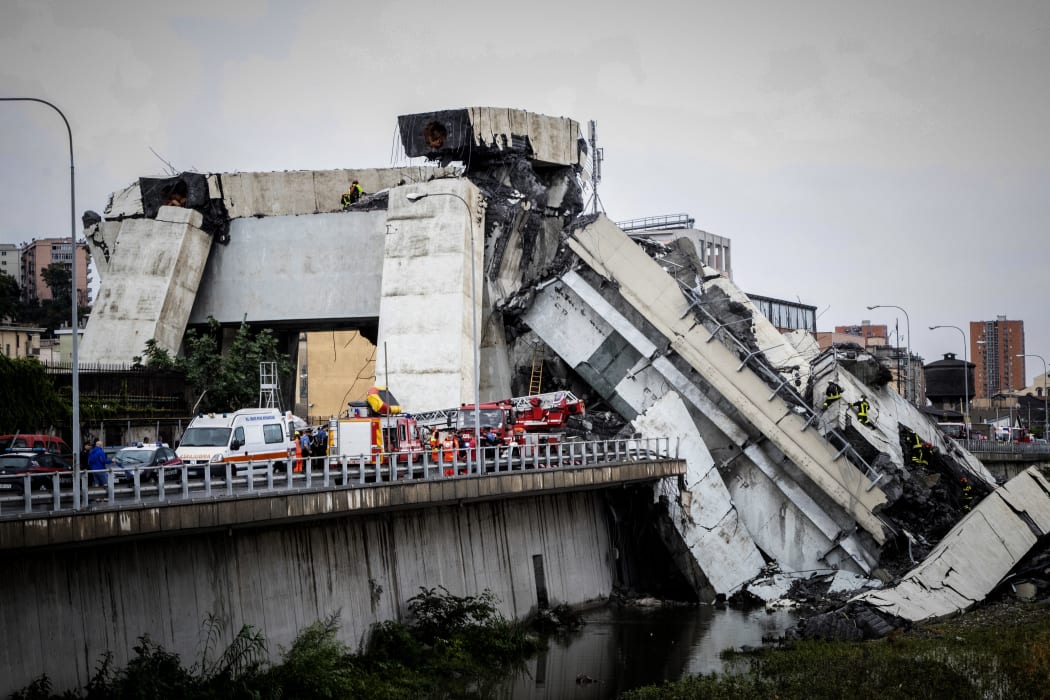 Rescue workers on a part of a Morandi motorway bridge after a section collapsed earlier in Genoa.