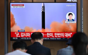 People watch a television screen showing a news broadcast with file footage of a North Korean missile test, at a railway station in Seoul on May 25, 2022, after North Korea fired three ballistic missiles towards the Sea of Japan according to South Korea's military. (Photo by JUNG YEON-JE / AFP)