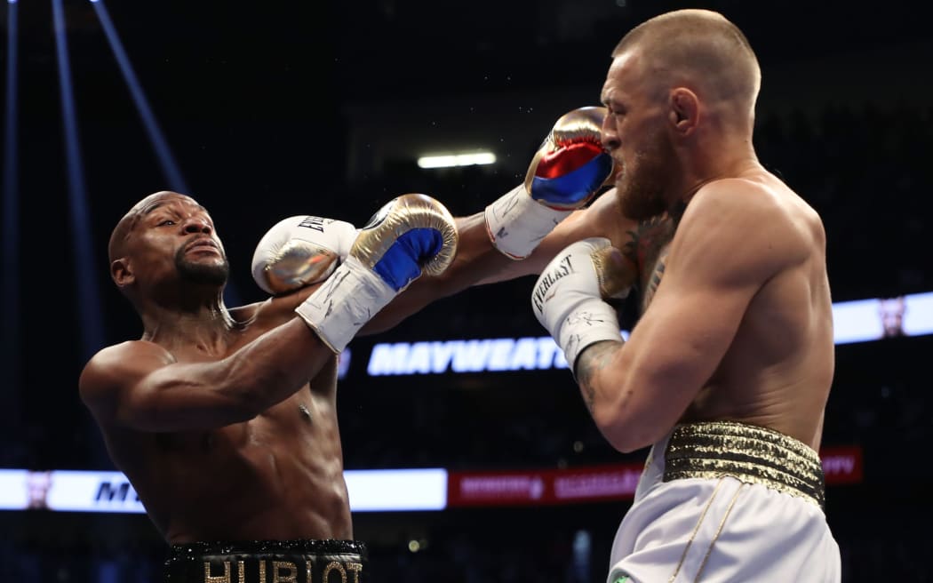 Conor McGregor throws a punch at Floyd Mayweather Jr. during their super welterweight boxing match on August 26, 2017.
