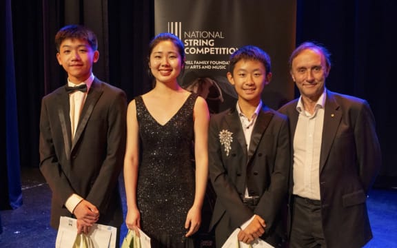 Three finalists of the 2024 National String Competition, Hayden Chiu, Sarah Lee and Ryan Yeh pose with adjudicator Dene Olding.