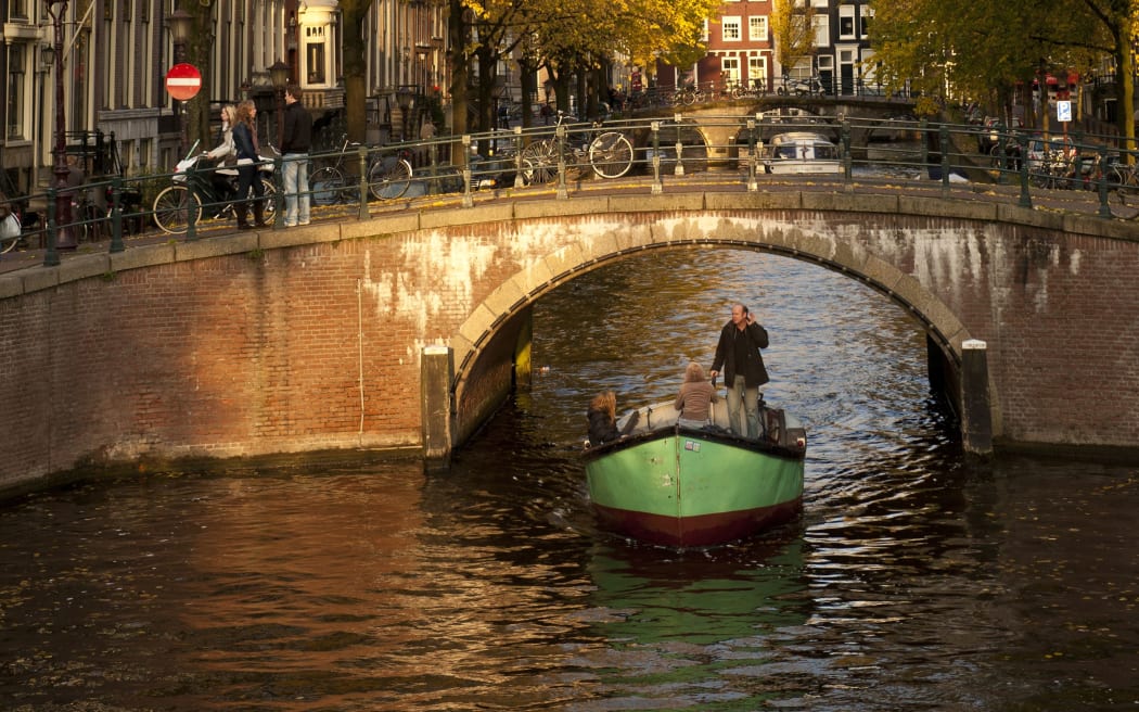 A boat passes under a bridge in Amsterdam.
