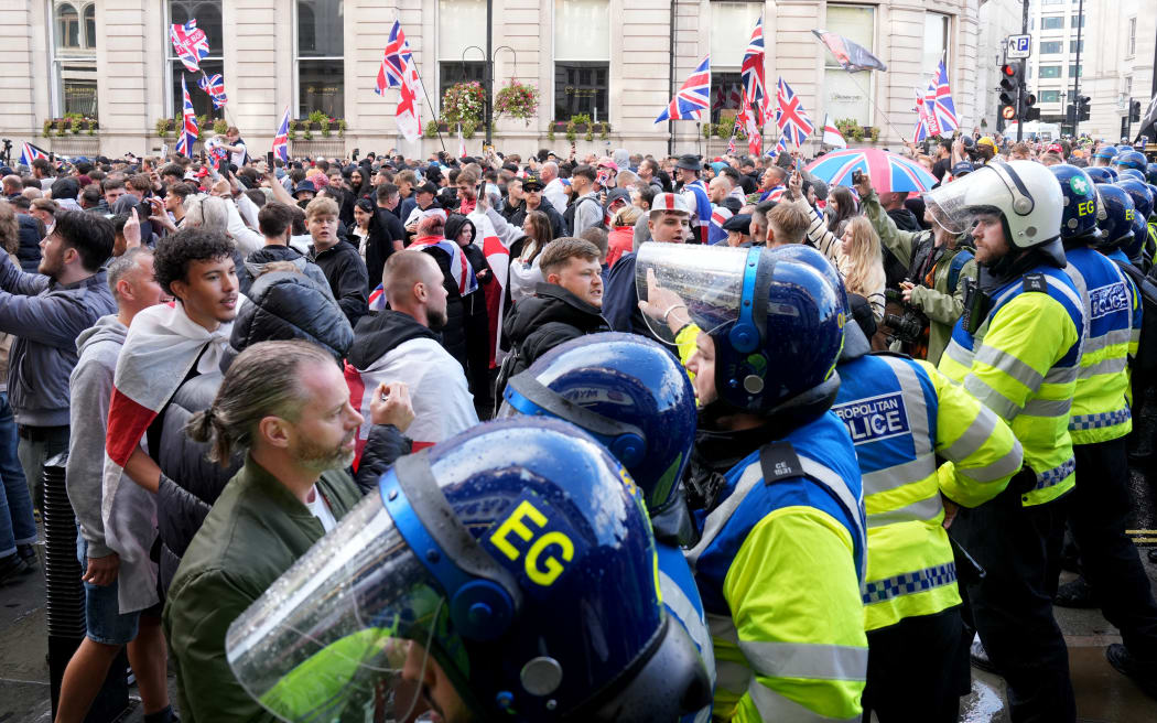Police Officers remonstrate with supporters of British far-right activist Tommy Robinson whose real name is Stephen Yaxley-Lennon, during a 'Free speech' march, in central London on September 13, 2025. (Photo by CARLOS JASSO / AFP)