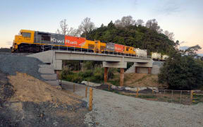 A freight train crosses the new Bridge 100, on Helleyer road, 15km from Helensville.  The new bridges have a concrete ballast tray deck which requires less maintenance than the old bridges, and can carry up to 25-tonne axle loads.