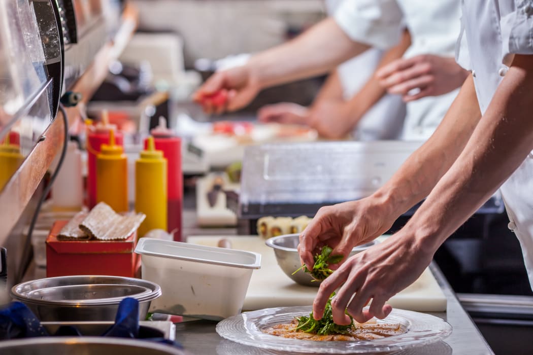 Cooks in a restaurant kitchen.