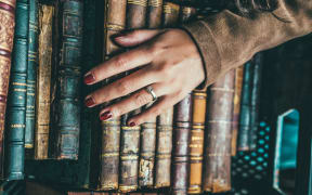Hand lies on old books