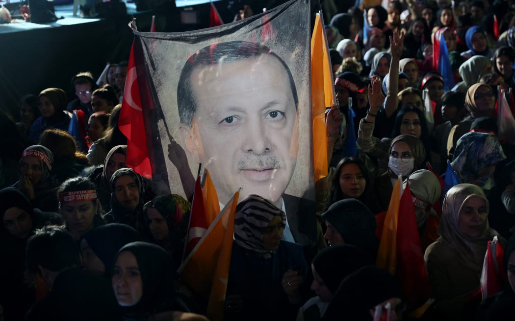 Supporters of Turkish President Tayyip Erdogan hold a flag of his portrait outside the AK Party headquarters in Ankara, Turkey, 15 May, 2023.