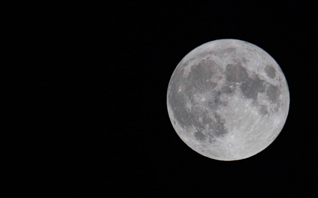 The first full moon of summer 2021, also known as the Strawberry Moon, the last supermoon of 2021 as seen in the Greek sky in Thessaloniki, Greece on June 24, 2021. (Photo by Nicolas Economou/NurPhoto) (Photo by Nicolas Economou / NurPhoto / NurPhoto via AFP)