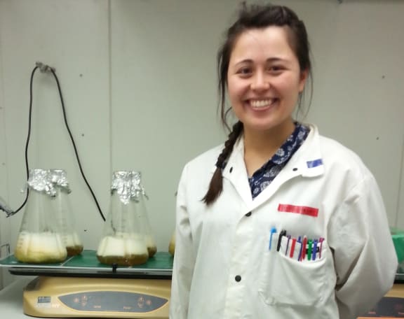 A picture of Amy Yewdall and flasks of bacteria growing proteins