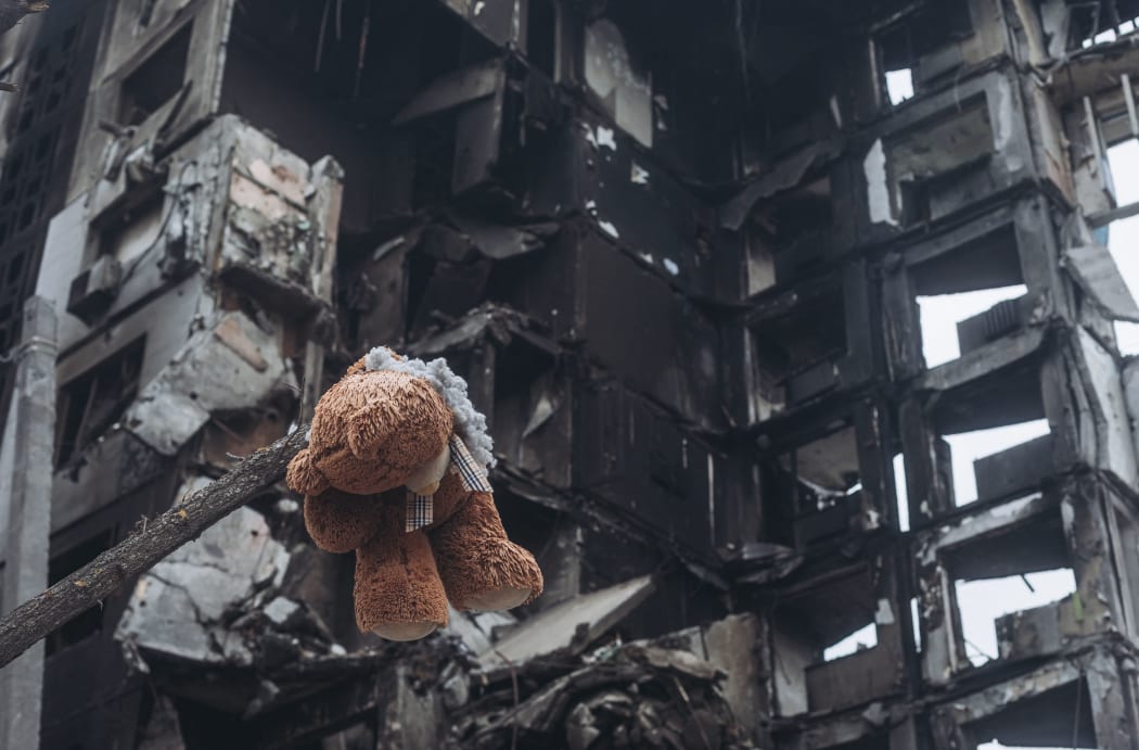 Borodyanka, UKRAINE - APRIL 6: A teddy bear hanging from a tree in front of a building bombed by the Russian army in Borodyanka (Ukraine), 6 April 2022.
