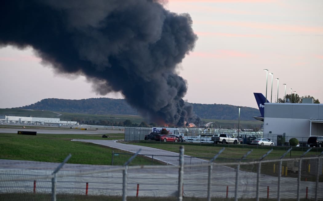 LOUISVILLE, KENTUCKY - NOVEMBER 04: Fire and smoke mark where a UPS cargo plane crashed near Louisville Muhammad Ali International Airport on November 04, 2025 in Louisville, Kentucky. The fully fueled plane crashed shortly after takeoff with a shelter-in-place order issued for within 5 miles of the airport.   Stephen Cohen/Getty Images/AFP (Photo by Stephen Cohen / GETTY IMAGES NORTH AMERICA / Getty Images via AFP)