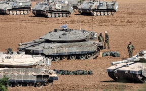 Israeli army Merkava battle tanks and other vehicles deploy along the border with the Gaza Strip in southern Israel on October 13, 2023. Thousands of people, both Israeli and Palestinians have died since October 7, 2023, after Palestinian Hamas militants entered Israel in a surprise attack leading Israel to declare war on Hamas in the Gaza Strip enclave on October 8. (Photo by JACK GUEZ / AFP)