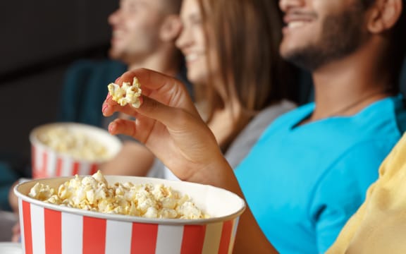 Group of people eating popcorn in the cinema