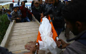 Mourners bury the body of 6 -year-old Palestinian Girl Esra Abu Khoussa.