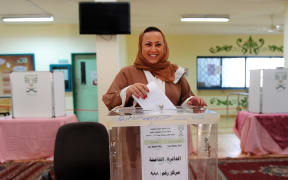 A Saudi woman arrives at a polling station to vote for the municipal elections