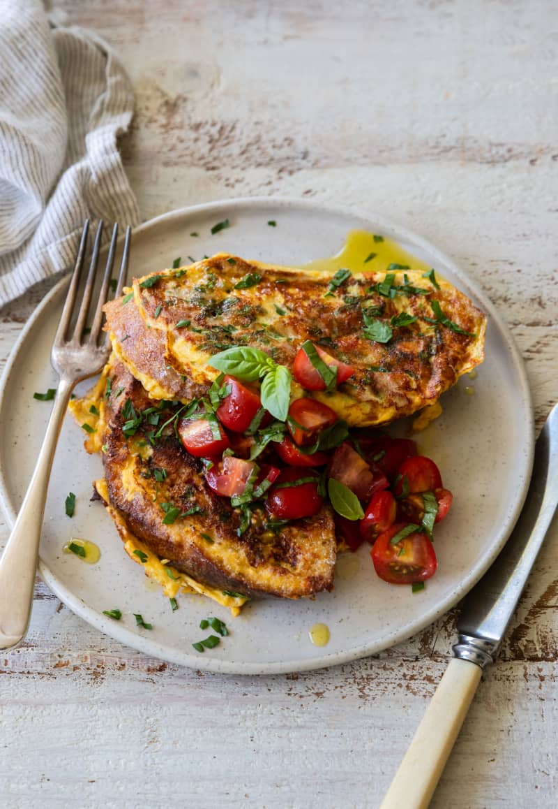 A plate of Savoury French toast with ham and wholegrain mustard, garnished with tomato salad.