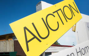 An auction sign outside a house for sale in Auckland.