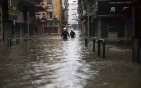Rescue workers make their way through floodwaters during a rescue operation during Super Typhoon Mangkhut in Macau.