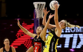 Kimiora Poi of the Tactix (L) challenges Maddy Gordon of the Pulse for possession.