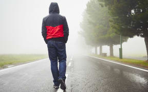 Lonely man is walking in mysterious fog