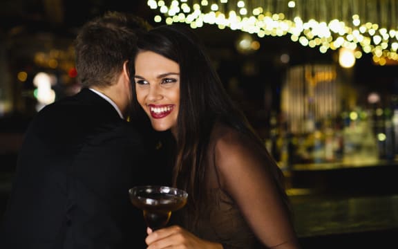 Smiling couple whispering at bar (Photo by Hybrid Images / Cultura Creative / Cultura Creative via AFP)
