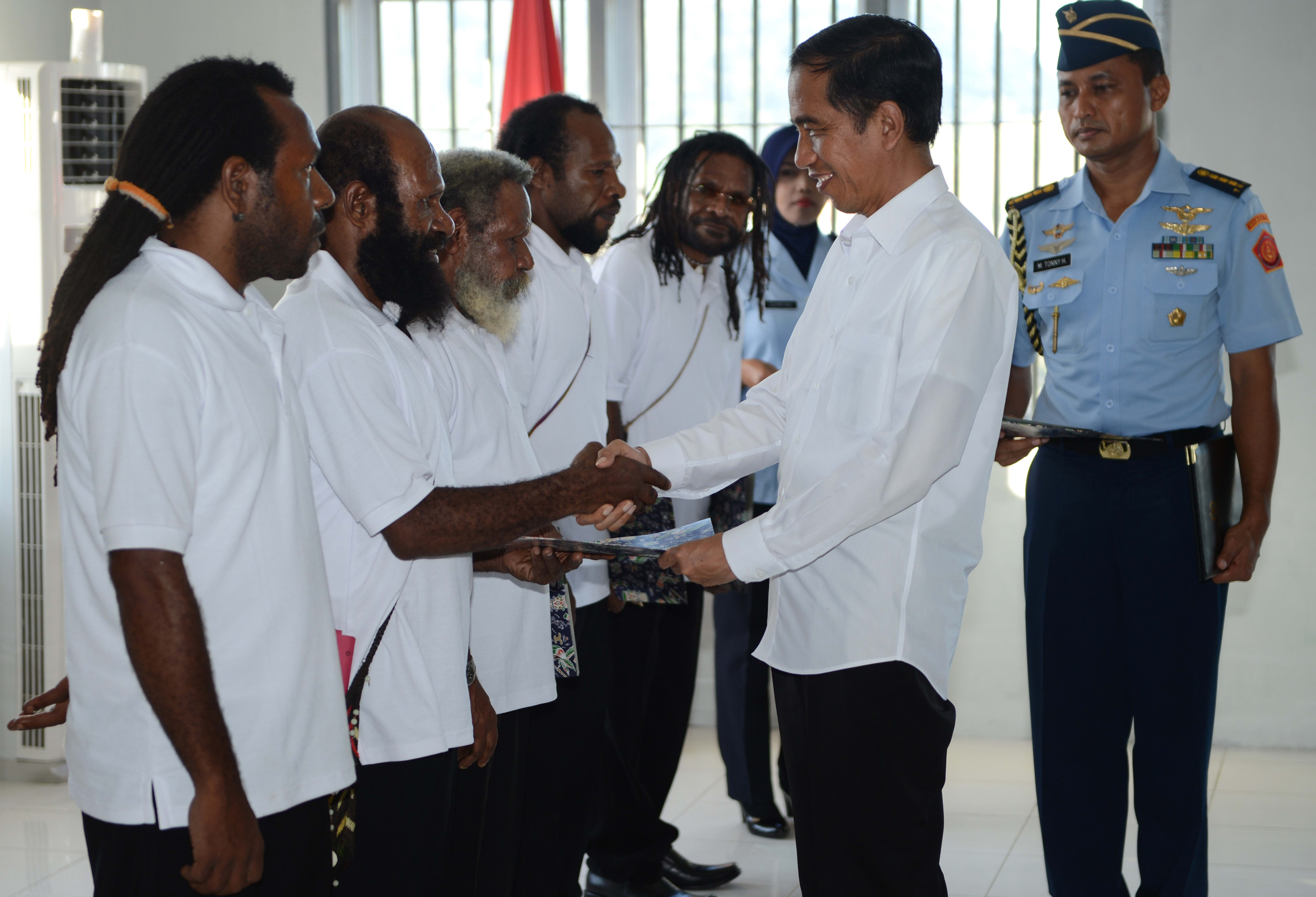 Indonesia's President Joko Widodo shakes hands with freed Papuan political prisoner Kimanus Wenda (2nd L) while four others Jefrai Murib (L) Apotnalogolik Lokobal (3rd L) Numbungga Telenggen (4th L) and Linus Hiluka (3rd R) during a ceremony at Abepura prison in Papua Province.