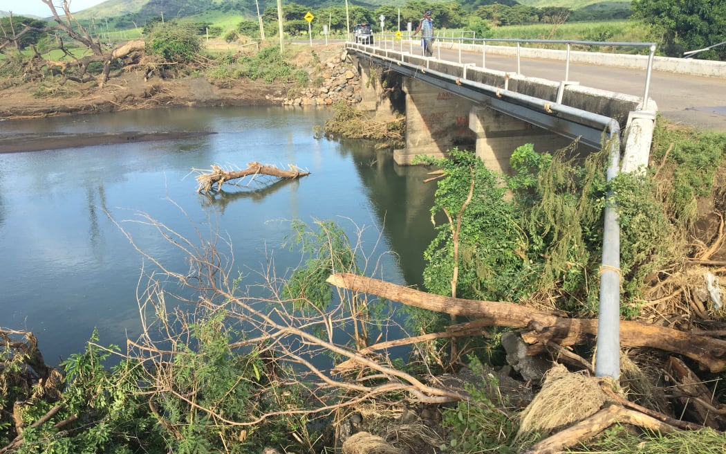 Uprooted trees litter a riverbank after flooding in Fiji in April 2018